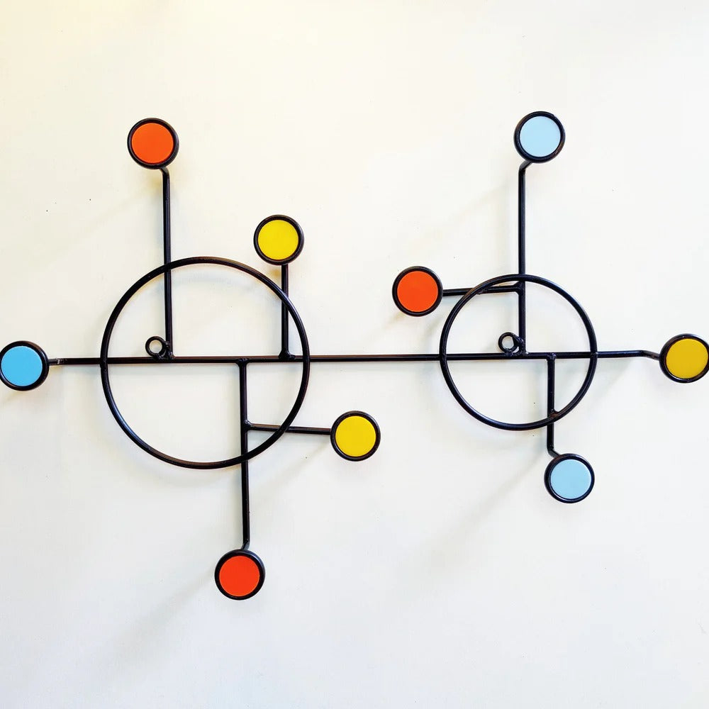 Close-up of metal hooks on circular wall shelf in minimalist Nordic design